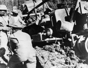 Black soldiers working on freeing a D8 dozer buried in mud on the Alaska Highway. 1942