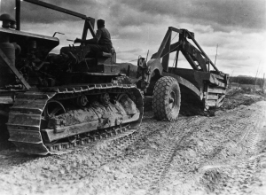 Black soldier operating D8 dozer and carryall along Alaska Highway.