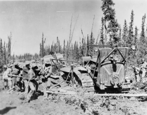 Black soldiers using logs for corduroy to free a D8 bulldozer stuck in the mud 1942.