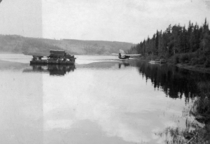 Teslin River pontoon ferry with truck and plane bringing 93rd Black Soldiers mail at Johnsons Crossing. 1942