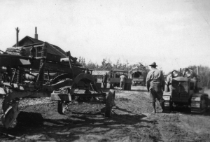 Bulldozers and graders from the Alaska Highway parked outside the small village of Tagish. 1942