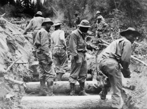 Black soldiers using handtools to build a culvert for drainage along the Alaska Highway. 1942