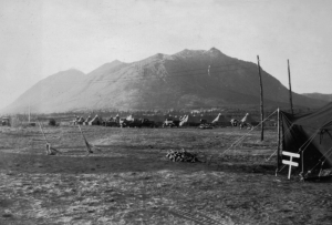 The 93rd Regiment encamped near the airfield. Caribou Mountain overshadows the pyramidal tents. 1942