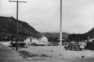 Carcross was a small village bordered by Caribou and Nares Mountains with planked sidewalks, a white church, a hotel and bar, train depot and Watson store. 1942