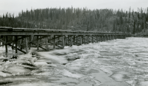  Ice cakes float under wooden Teslin River Bridge at Johnsons Crossing.1942