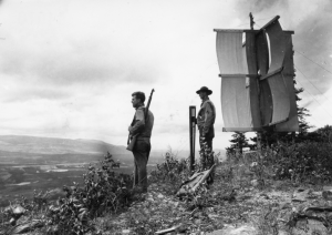 T/Sgt Neilsen and Pfc Dooley of Company D of the 29th Topo Engineers stand near signal on Mt. Baldy. 4 Aug 42