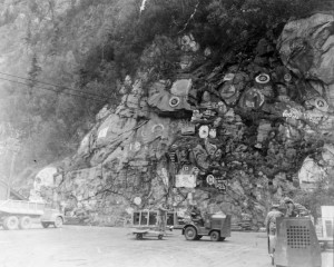 Skagway Harbor's rock wall displays Soapy Smith's skull and ship's emblems that departed from Skagway. 1942